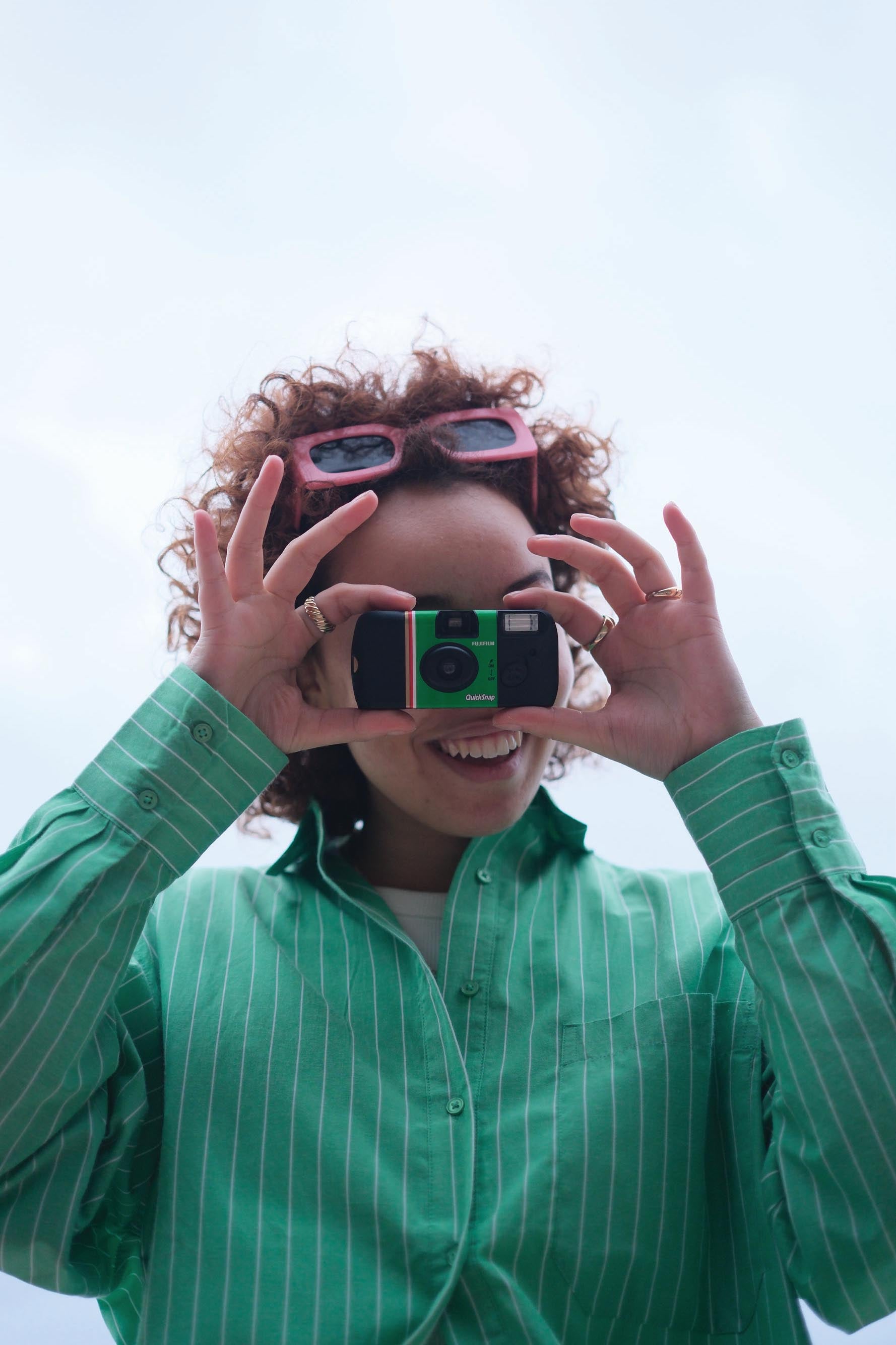 A person looking through a FUJIFILM QuickSnap camera